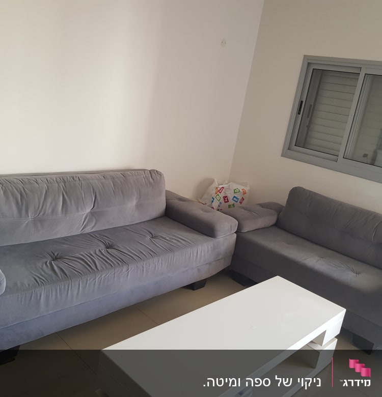 ספות אפורות בחדר עם שולחן לבן